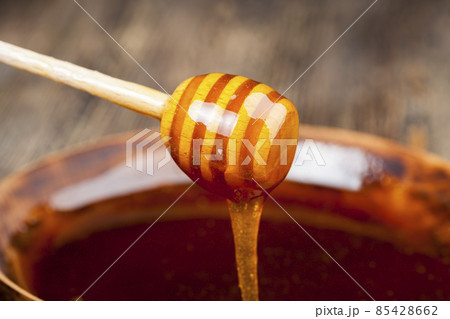a spoon for honey together with high-quality bee honey 85428662