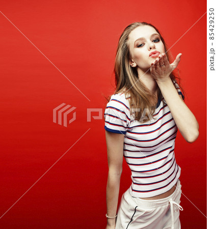 young pretty emitonal posing teenage girl on bright red background, happy smiling lifestyle people concept young pretty emitonal posing teenage girl on bright red background, happy smiling lifestyle people concept 85429250