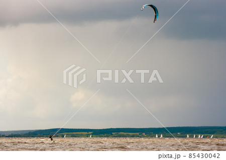 Kitesurfing on the water on the waves with a parachute wing. Wind, speed. Kitesurfing on the water on the waves with a parachute wing. Wind, speed. 85430042