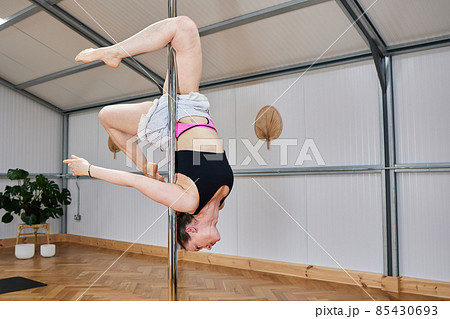 woman face down suspended on pole bar. body conscious concept woman face down suspended on pole bar. body conscious concept 85430693