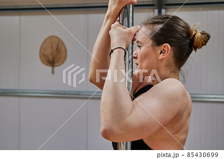 middle-aged woman lifestyle performing pole dancing exercises in a nice yoga studio middle-aged woman lifestyle performing pole dancing exercises in a nice yoga studio 85430699