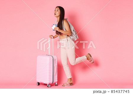 Travelling, holidays and vacation concept. Full-length of worried running asian girl tourist being late for her flight, carry suitcase and backpack, holding passport with plane tickets in hand 85437745