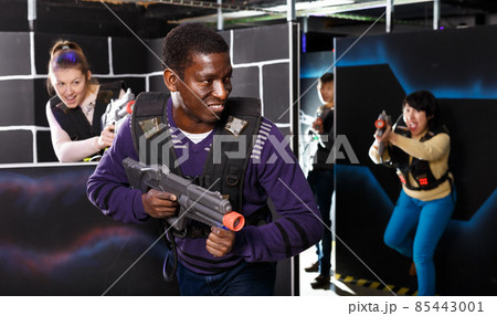African man playing laser tag with friends African man playing laser tag with friends 85443001
