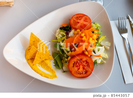 Salad with hummus and nachos served on plate Salad with hummus and nachos served on plate 85443057