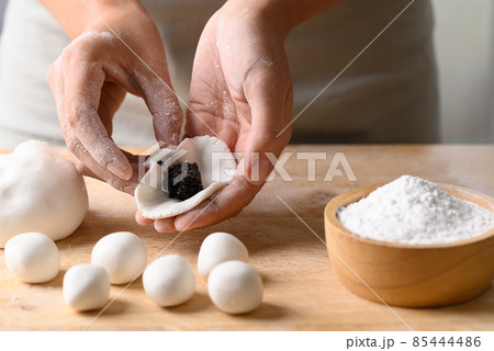 Hand making Tangyuan, Chinese dessert made of ball glutinous rice flour and filled with black sesame Hand making Tangyuan, Chinese dessert made of ball glutinous rice flour and filled with black sesame 85444486