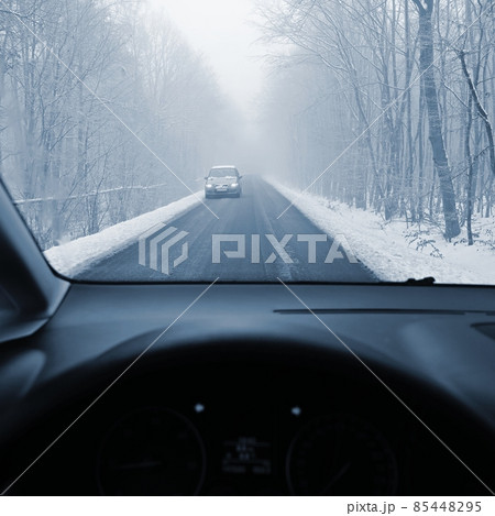 Driving the car in the winter. View from the interior of a car on a snowy road by the eyes of the driver. Concept for driving safety in the winter. 85448295