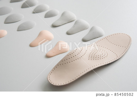 Orthopedic insole on a white background. Treatment and prevention of flat feet and foot diseases. Foot care, foot comfort. Wear comfortable shoes. 85450502