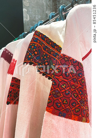 Garage sale in town hall, Tlum and Kram. Ukrainian clothes - traditional embroidered shirts. Secondhand goods on flea market, thrift shopping concept. Selective focus. Vertical image Garage sale in town hall, Tlum and Kram. Ukrainian clothes - traditional embroidered shirts. Secondhand goods on flea market, thrift shopping concept. Selective focus. Vertical image 85451236