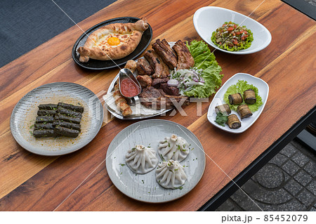 Festive feast with different dishes from Georgia, Armenia and Russia. Caucasian cuisine. Various delicious dishes on the wooden table.  85452079