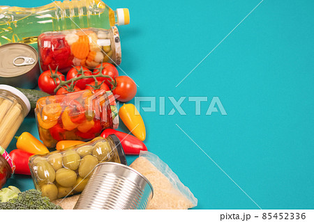 Food donations and different groceries on blue background with copy space - pasta, vegatables, canned food, baguette, cooking oil, tomatoes, cheese. Food bank, food delivery concept. Selective focus Food donations and different groceries on blue background with copy space - pasta, vegatables, canned food, baguette, cooking oil, tomatoes, cheese. Food bank, food delivery concept. Selective focus 85452336