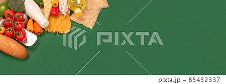 Banner with different groceries, food donations on green background with copy space - pasta, vegatables, canned food, baguette, cooking oil, tomatoes, cheese. Food bank, food delivery concept 85452337