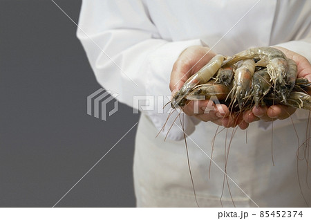 chef holding raw shrimps 85452374