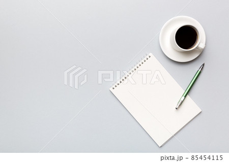 Modern office desk table with notebook and other supplies with cup of coffee. Blank notebook page for you design. Top view, flat lay 85454115