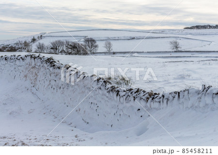 Winter view of snow covered countryside with dry stone wall. Derbyshire, UK. Winter view of snow covered countryside with dry stone wall. Derbyshire, UK. 85458211