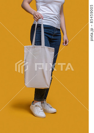 Female demonstrating her stylish bag before the camera 85459005