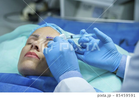 Doctor gives the patient injection for anesthesia 85459591