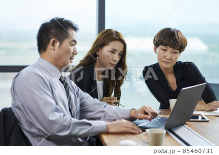 three asian corporate executives meeting in office discussing business using laptop three asian corporate executives meeting in office discussing business using laptop 85460731