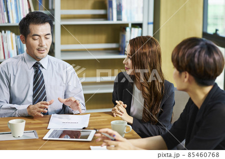 three asian businesspeople man and woman sitting at desk discussing business proposal in office 85460768
