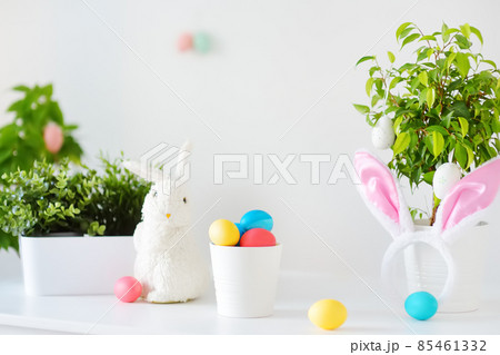 Colored eggs, cute little bunny and rabbit ears on the table on Easter day. Celebrating Easter at spring. Painting eggs. 85461332