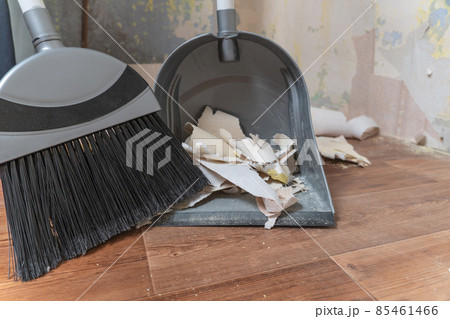 Clean up garbage after repairs.Sweep up construction debris with a brush in a dustpan.Sweeping at home.Tools for cleaning the house.Make home repairs.The dust.Wall repair.Torn wallpaper from the wall Clean up garbage after repairs.Sweep up construction debris with a brush in a dustpan.Sweeping at home.Tools for cleaning the house.Make home repairs.The dust.Wall repair.Torn wallpaper from the wall 85461466
