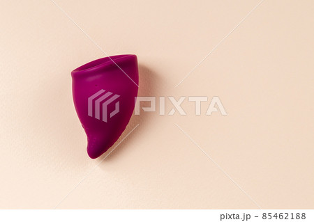 Bag shaped Menstrual cup on beige background 85462188