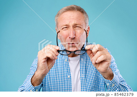 Mature man squinting wearing eyeglasses, looking at camera 85462379