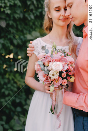 Bride and groom at wedding Day walking Outdoors on spring nature. Bridal couple, Happy Newlywed woman and man embracing in green park. Loving wedding couple outdoor. Wedding shot of bride and groom in 85462500