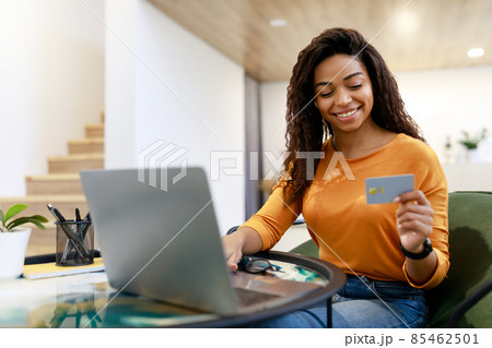 Happy woman holding debit credit card, using pc 85462501