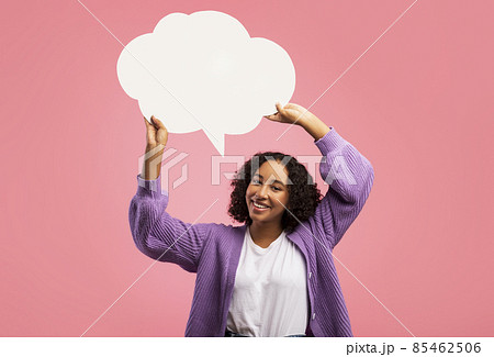 Cheerful black woman holding blank speech bubble on pink studio background, mockup for your ad design 85462506