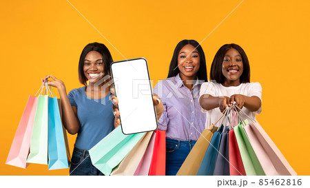 Online Sales. Thre Black Females With Bright Shopping Bags Showing Blank Smartphone Online Sales. Thre Black Females With Bright Shopping Bags Showing Blank Smartphone 85462816