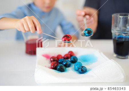 Mature father and her son are painting eggs for Easter. Happy family preparing for Easter. Mature father and her son are painting eggs for Easter. Happy family preparing for Easter. 85463343