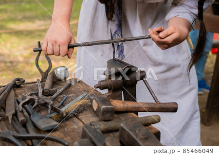 Professional blacksmith woman working with metal on anvil - close up Professional blacksmith woman working with metal on anvil - close up 85466049