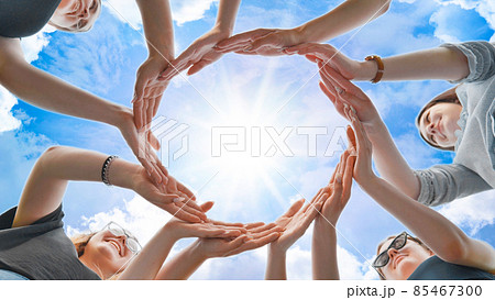 Friends make a circle from their palms against the background of a fabulous sky. Friends make a circle from their palms against the background of a fabulous sky. 85467300