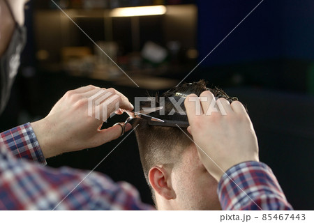 Close-up of hairdresser male hands during cutting male hair Close-up of hairdresser male hands during cutting male hair 85467443