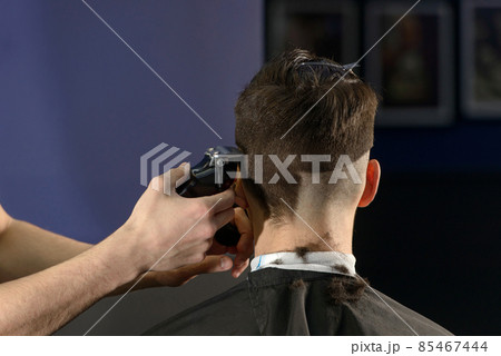 Close up of hair clipper. Person getting a haircut Close up of hair clipper. Person getting a haircut 85467444