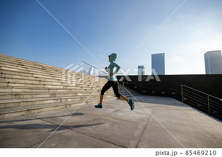 Fitness sports woman running up stairs in sunrise city Fitness sports woman running up stairs in sunrise city 85469210