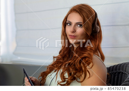 redhead woman music listening beautiful hairs headphones and phone relaxing lifestyle 85470238