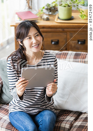 リビングルームでタブレットPCを見る女性 85472499