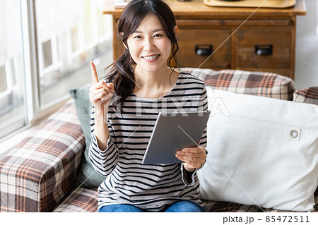 リビングルームでタブレットPCを見る女性 85472511