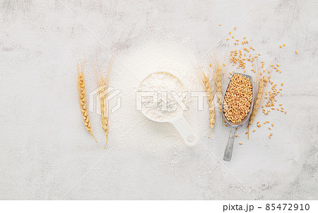 The ingredients for homemade pizza dough with wheat ears ,wheat flour and olive oil set up on white concrete background. top view and copy space. 85472910