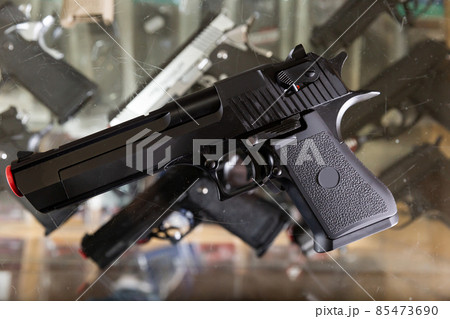 Pistol on showcase in weapon shop 85473690