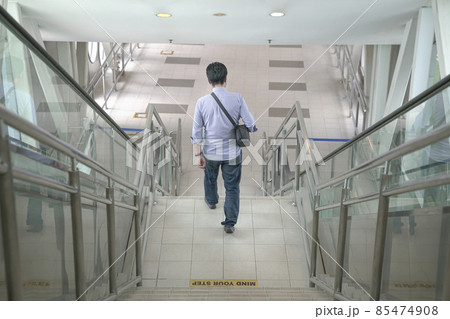 Man walking down the stairs inside a subway building. 85474908