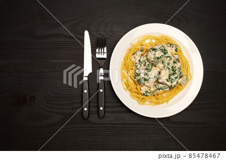 Portion of delicious meatballs with spinach in a creamy sauce and pasta on wooden background Portion of delicious meatballs with spinach in a creamy sauce and pasta on wooden background 85478467
