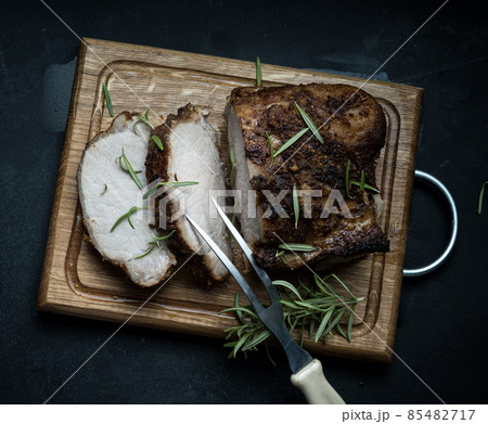 baked piece of pork meat in spices on a wooden board, cut into pieces. Eye of round roast steak baked piece of pork meat in spices on a wooden board, cut into pieces. Eye of round roast steak 85482717