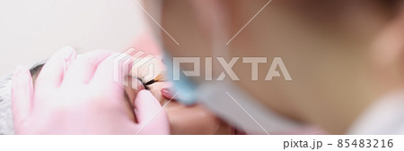 Master makes permanent makeup for eyelids of client in salon Master makes permanent makeup for eyelids of client in salon 85483216