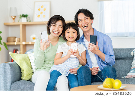 スマホを持つ若い家族 85483620