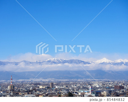 1月（冬）、高台から望む松本の街並みと、雲がかかった北アルプス 長野県松本市 85484832
