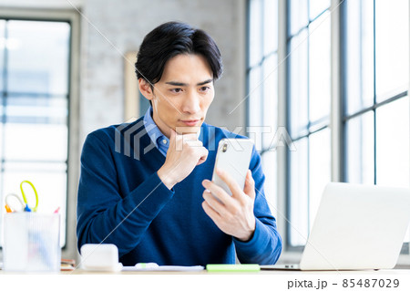 スマホを見るテレワークのミドルの男性 85487029