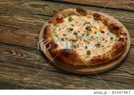 Italian Pizza Quattro formaggi on wooden table Italian Pizza Quattro formaggi on wooden table 85487967
