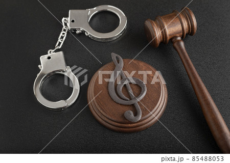 Treble clef sign and handcuffs. Illegal use of someone elses music. Copyright infringement. Music Licensing. 85488053